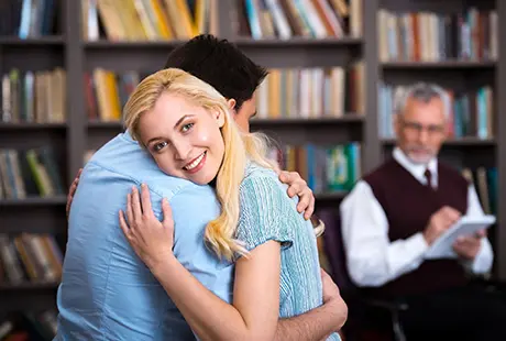 Couple are hugging each other in library